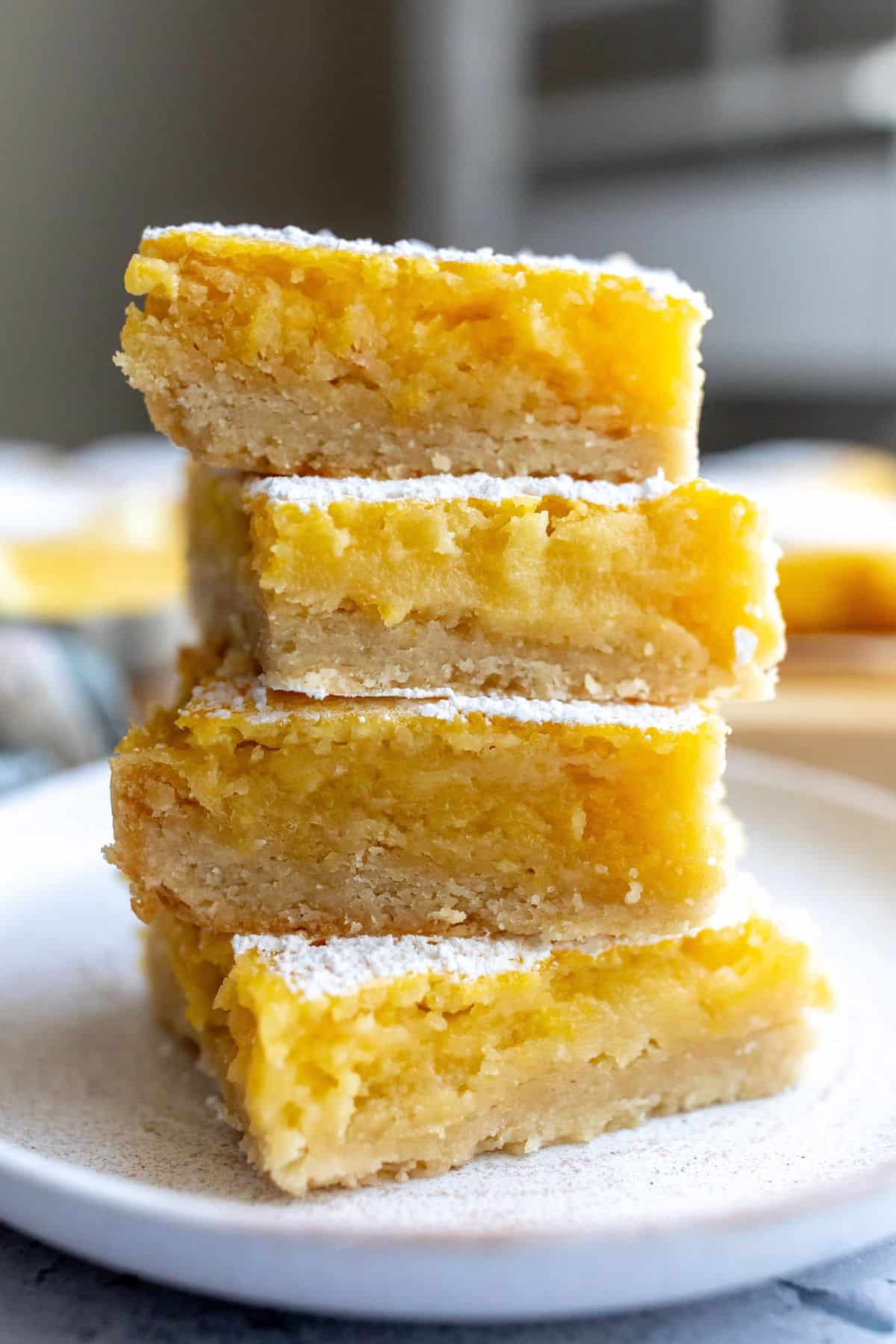 Lemon Cookie Bars stacked on each other on a plate.