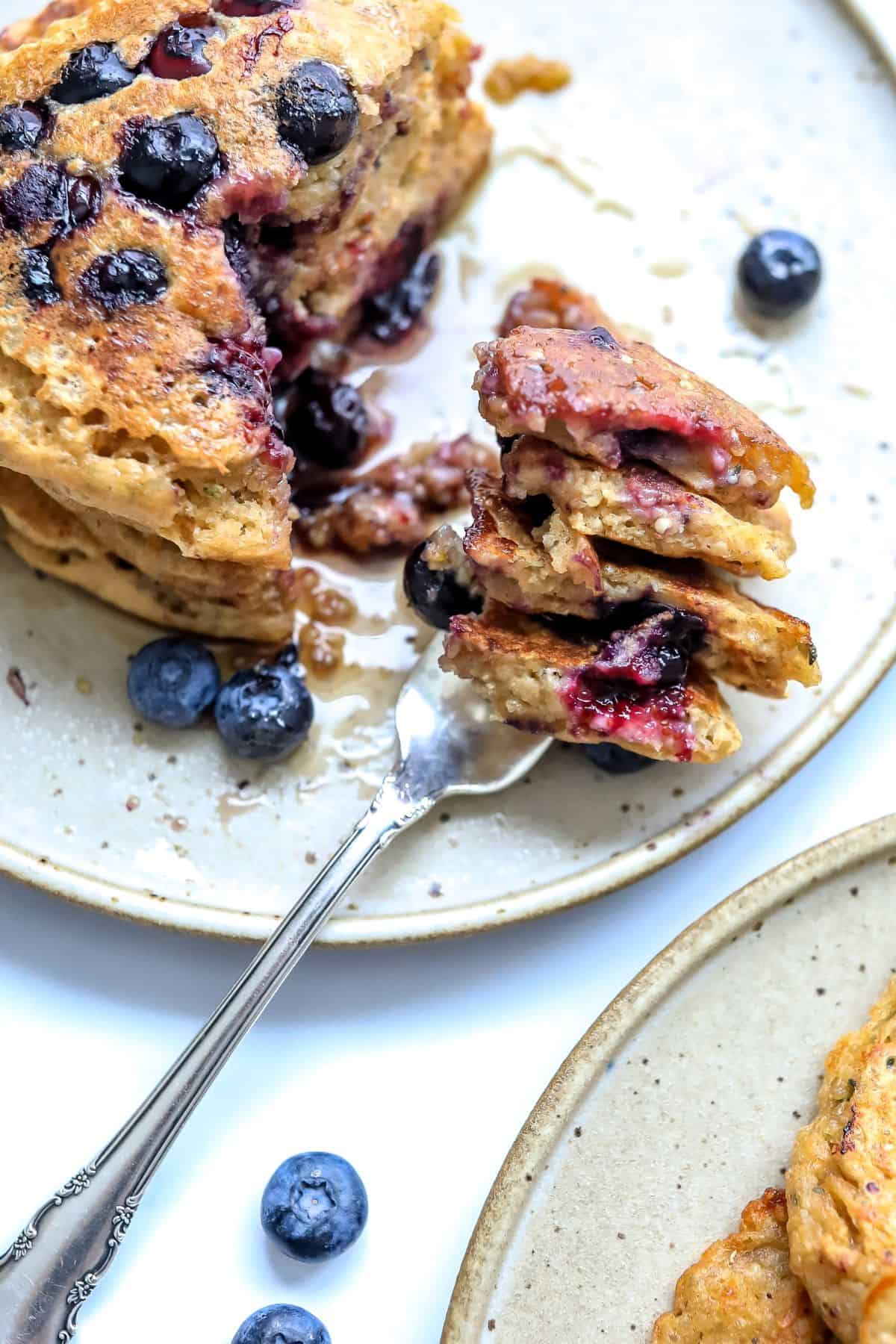 healthy whole wheat pancakes with berries and a silver fork.
