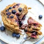 healthy whole wheat pancakes with berries and a silver fork.