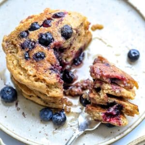 healthy whole wheat pancakes with berries and a silver fork.