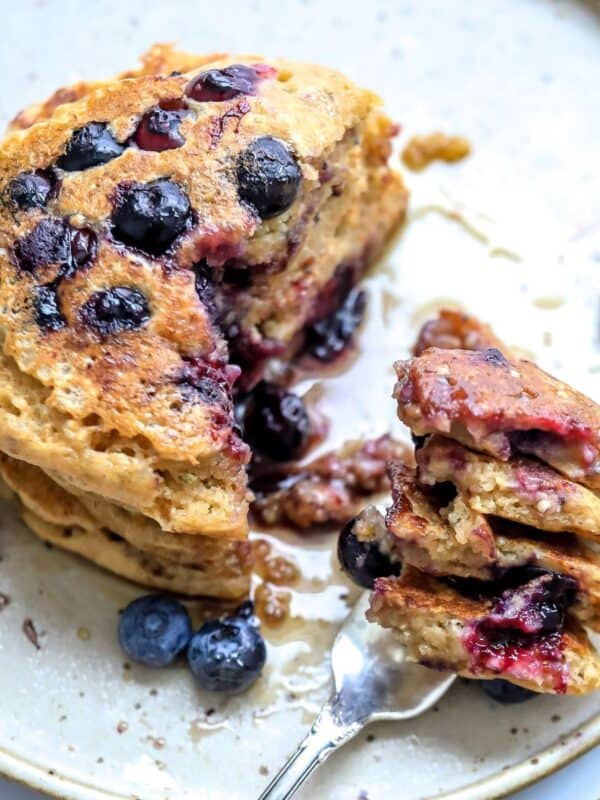healthy whole wheat pancakes with berries and a silver fork.