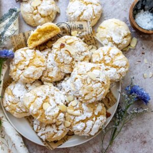 lemon almond cookies with crinkles on a white plate.