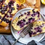 Lemon Blueberry bread with lemons on the side, one a plate with a silver fork.