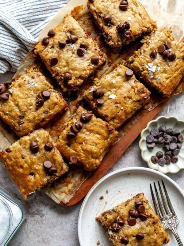 Peanut Butter Banana Bars on a cutting board with a plate on the side.