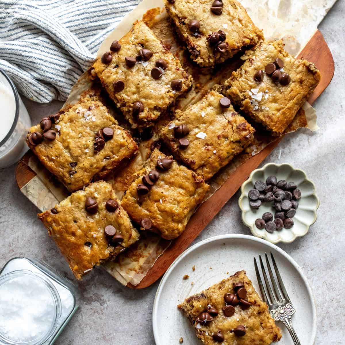 Peanut Butter Banana Bars on a cutting board with a plate on the side.