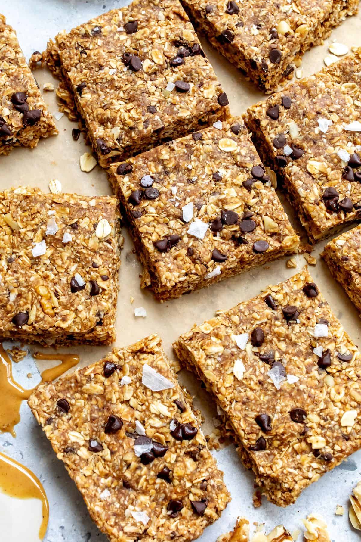 No bake granola bars on parchment paper with peanut butter on the side. 
