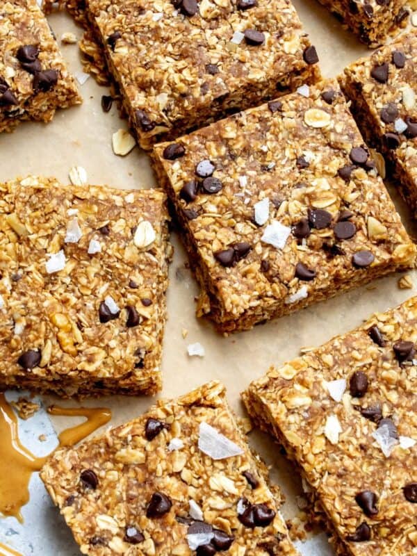 No bake granola bars on parchment paper with peanut butter on the side.