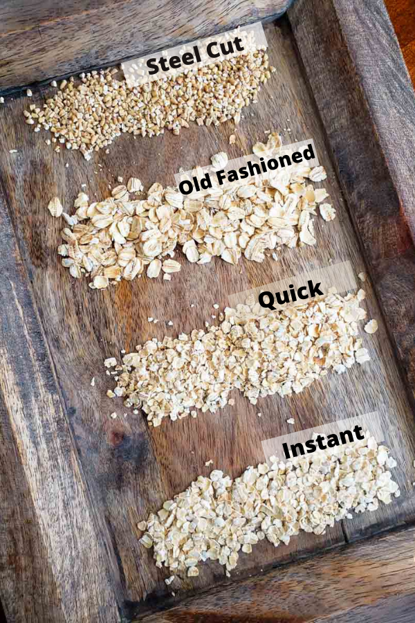 Different styles of oats. Steel cut, old fashioned, quick and instant all lined up on a cutting board. 