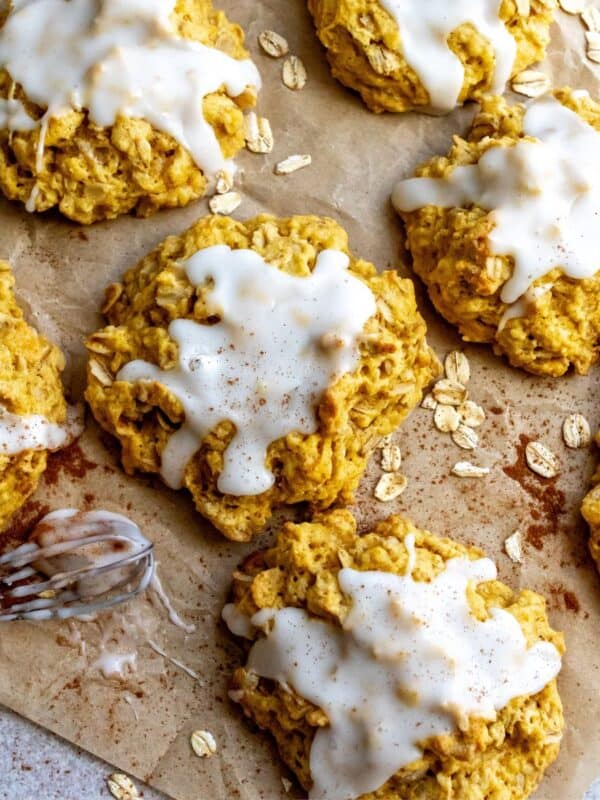 Pumpkin Pie Cookies on parchment paper with oats on the side.