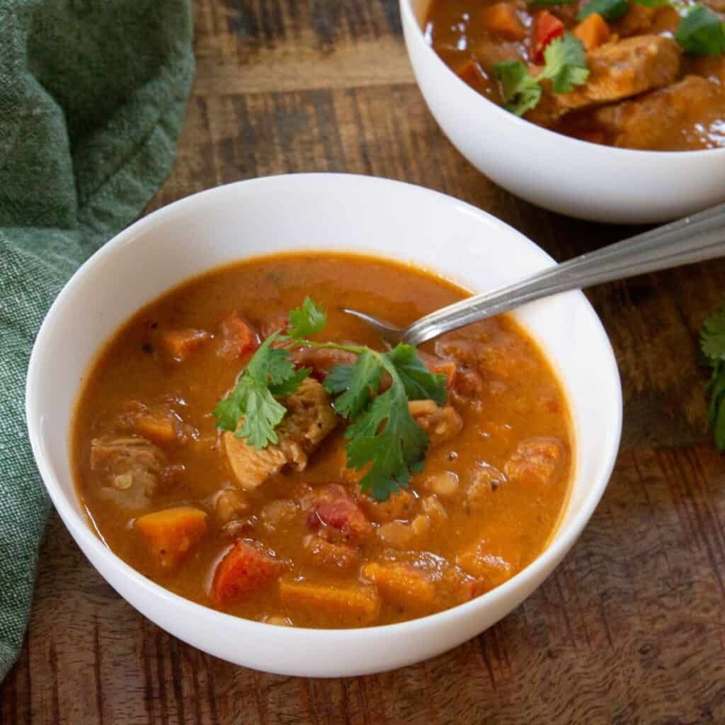 Sweet Potato Stew in a white bowl served with cilantro over the top. 