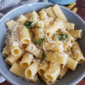 Healthier Cacio e PePe in a gray bowl with fresh parsley on top for color