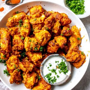 Boneless Wings in Air Fryer on a white plate with ranch on the side.
