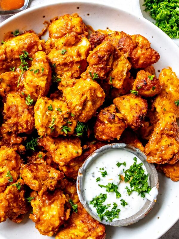 Boneless Wings in Air Fryer on a white plate with ranch on the side.