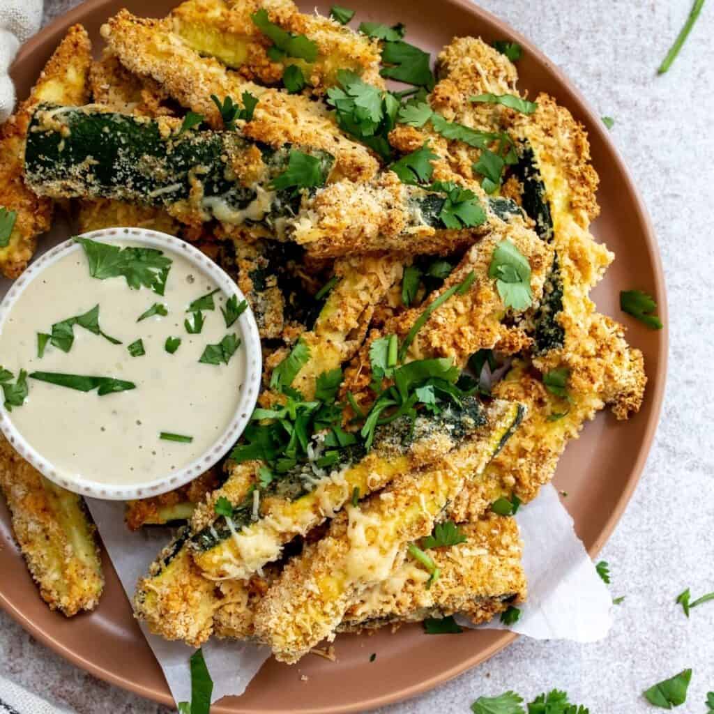 Air fryer Zucchini fries  on a plate with dip.