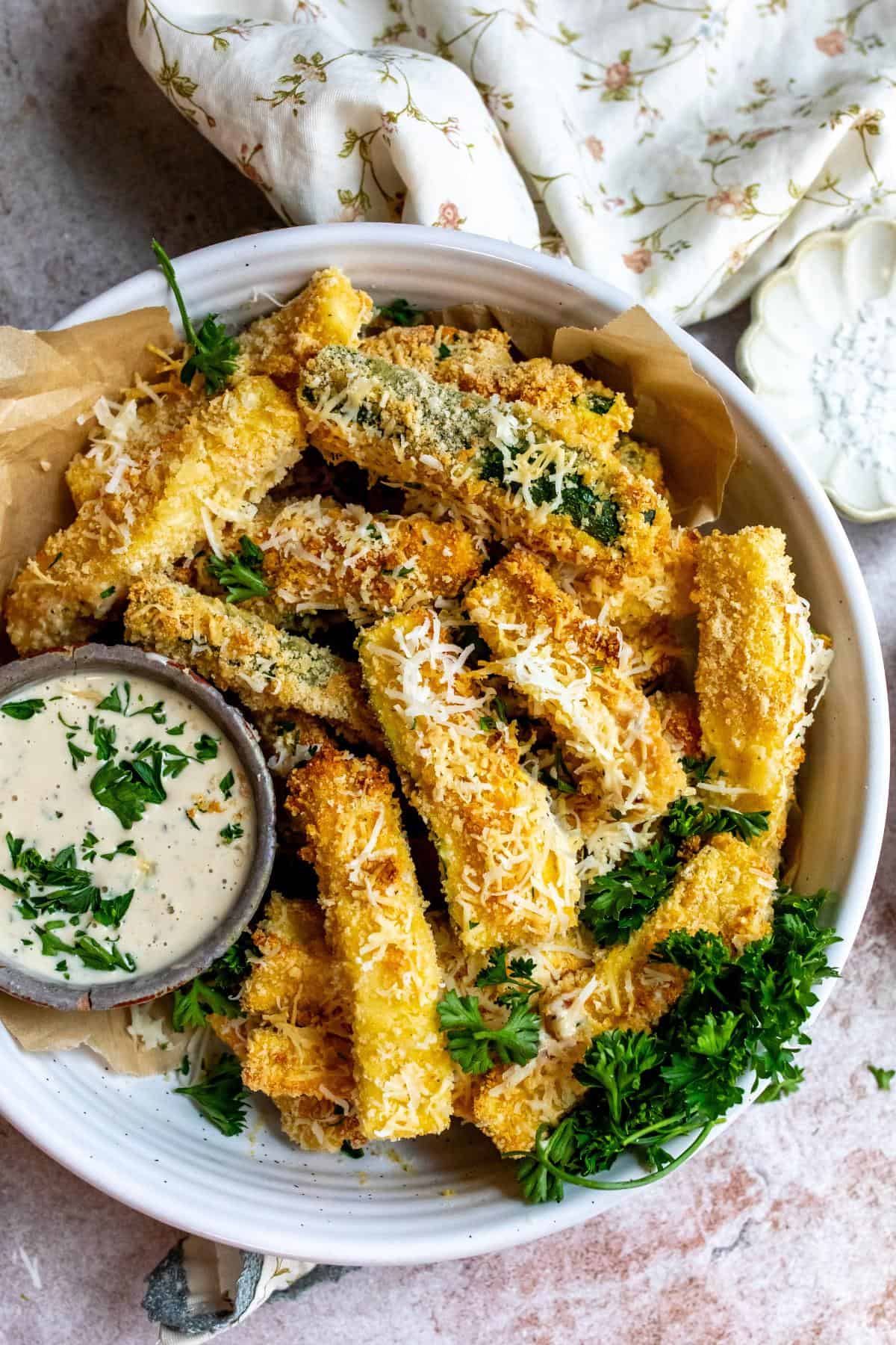 Air fryer Zucchini fries on a plate with dip.