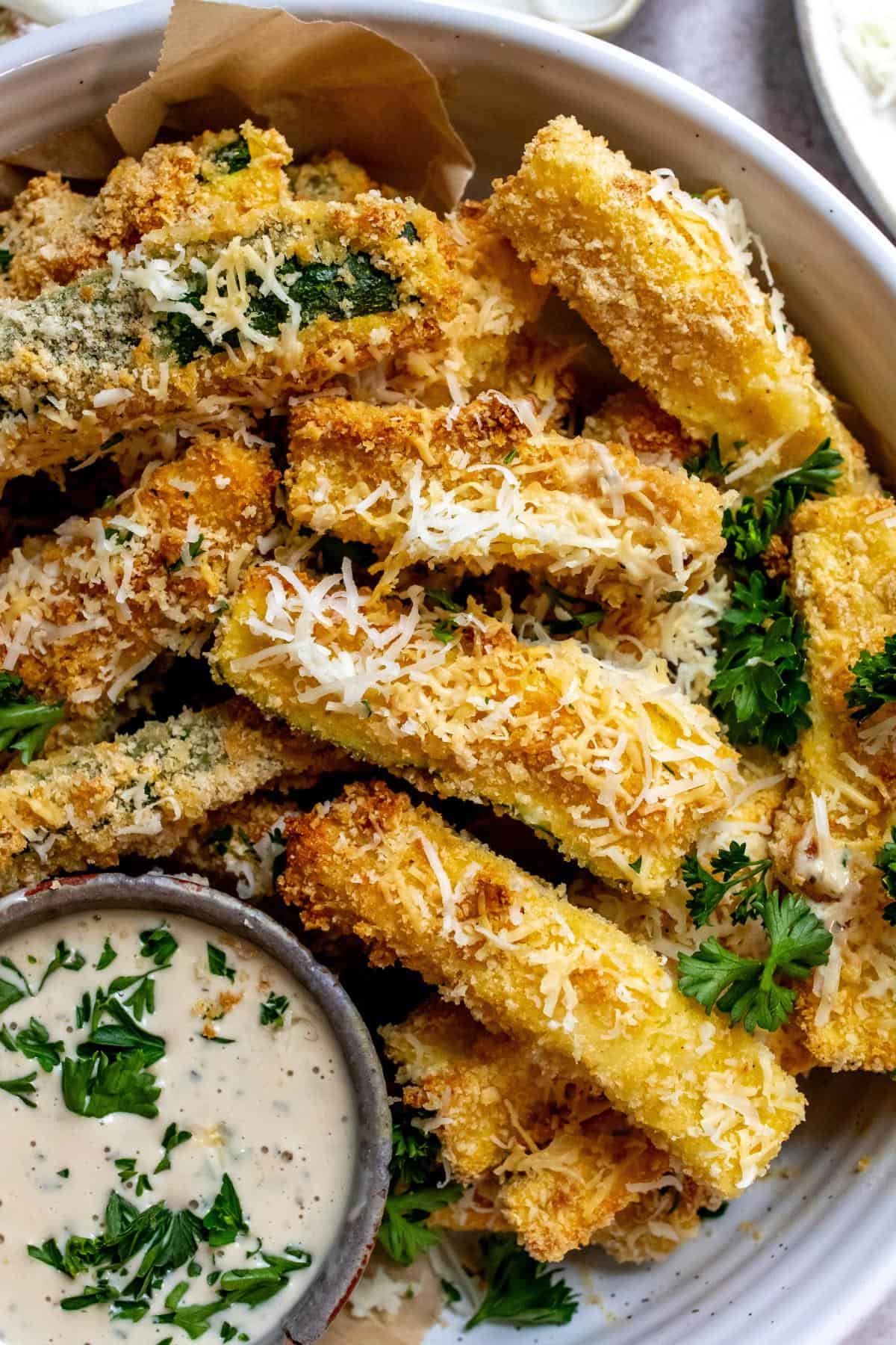 Air fryer Zucchini fries on a plate with dip.