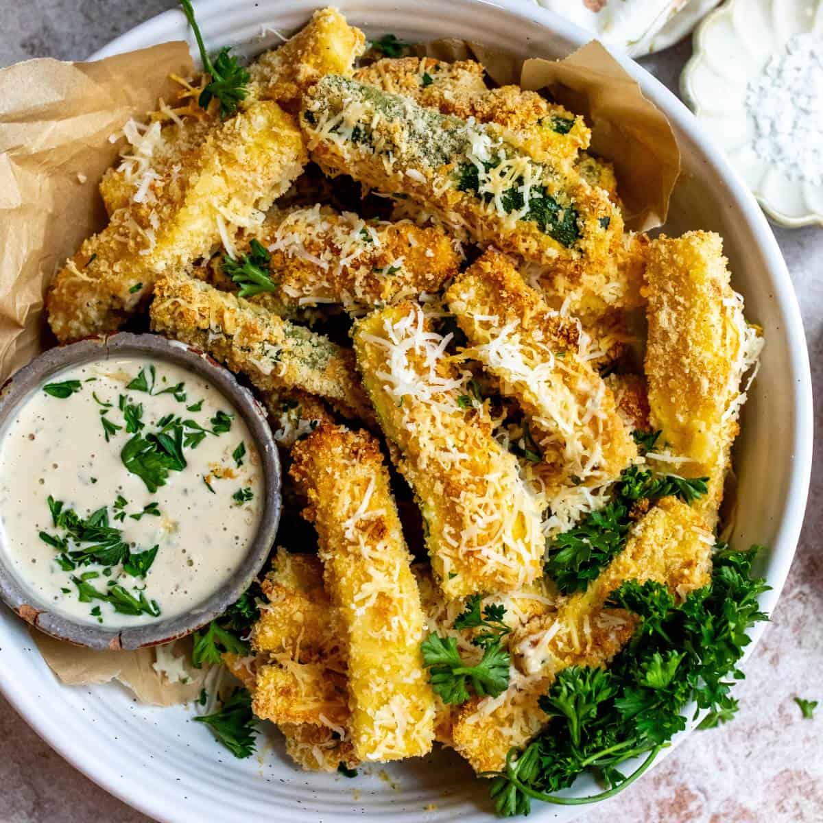 Air fryer Zucchini fries on a plate with dip.