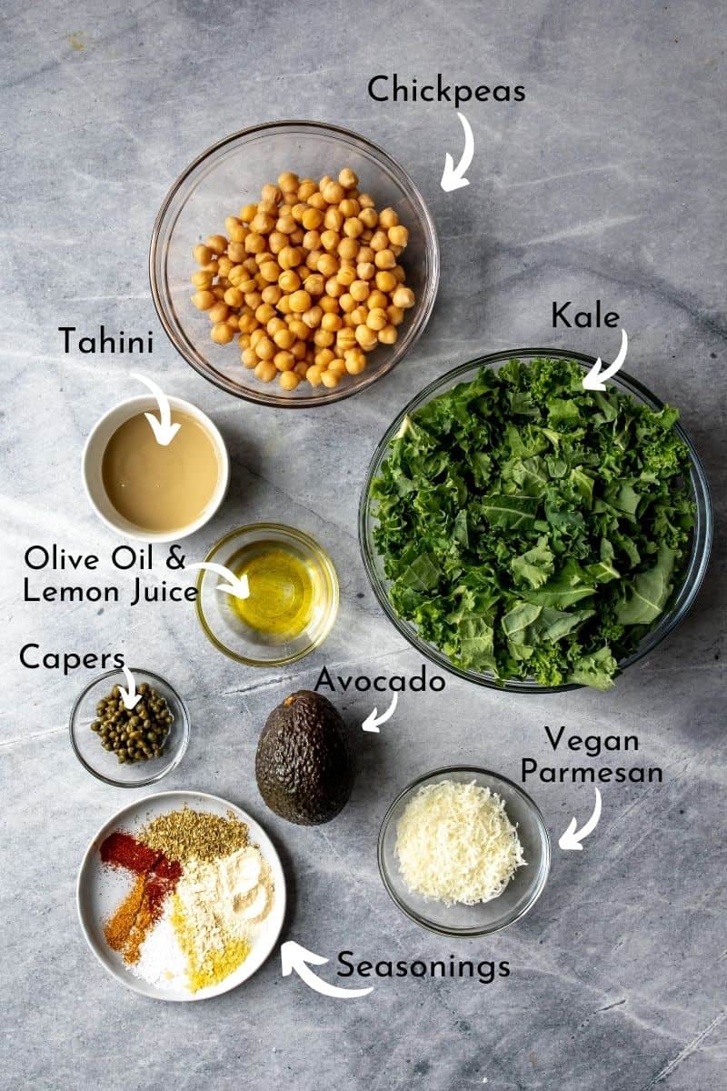 Ingredients for healthy kale caesar on a grey counter top for kale and chickpea salad.