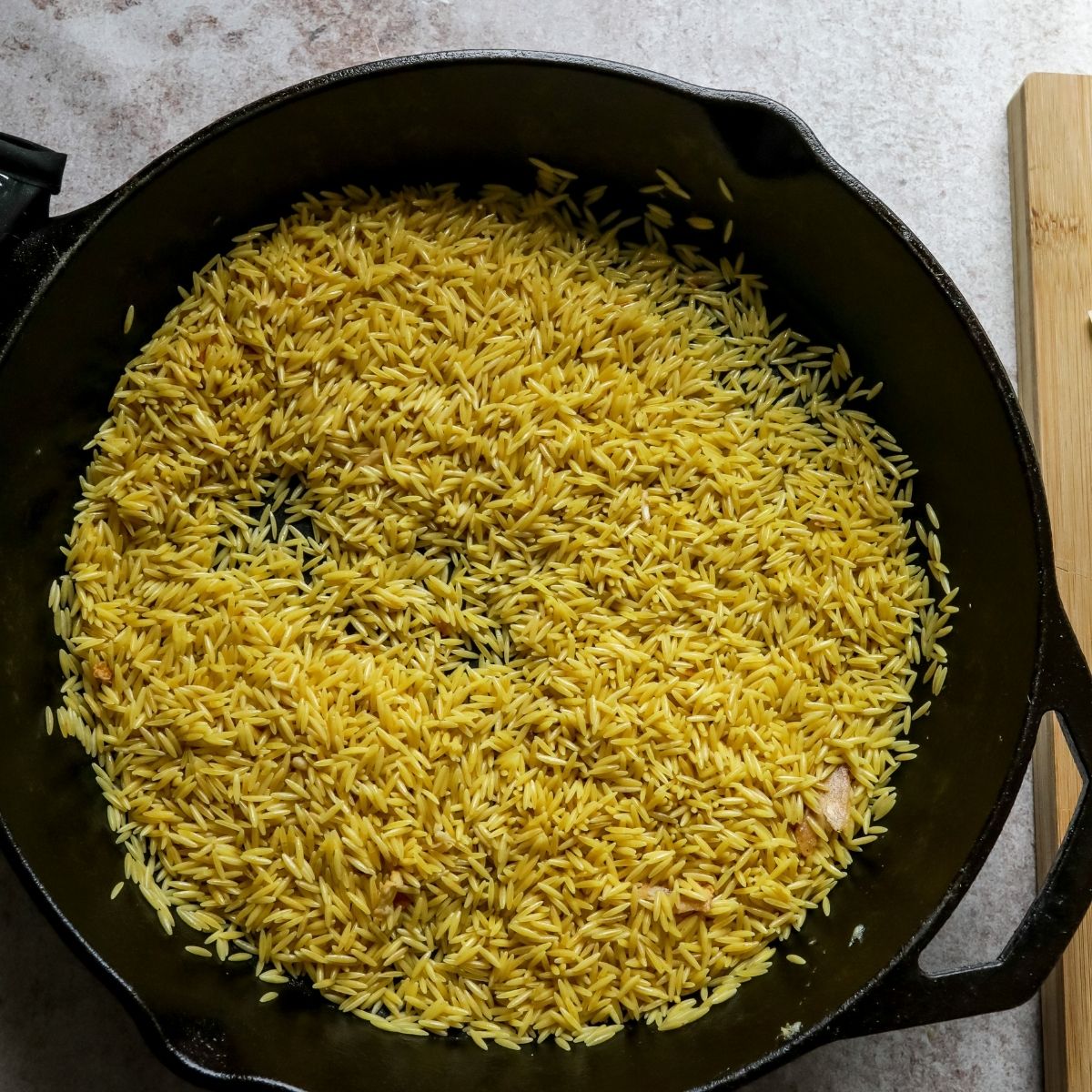 Orzo in a skillet browning. 