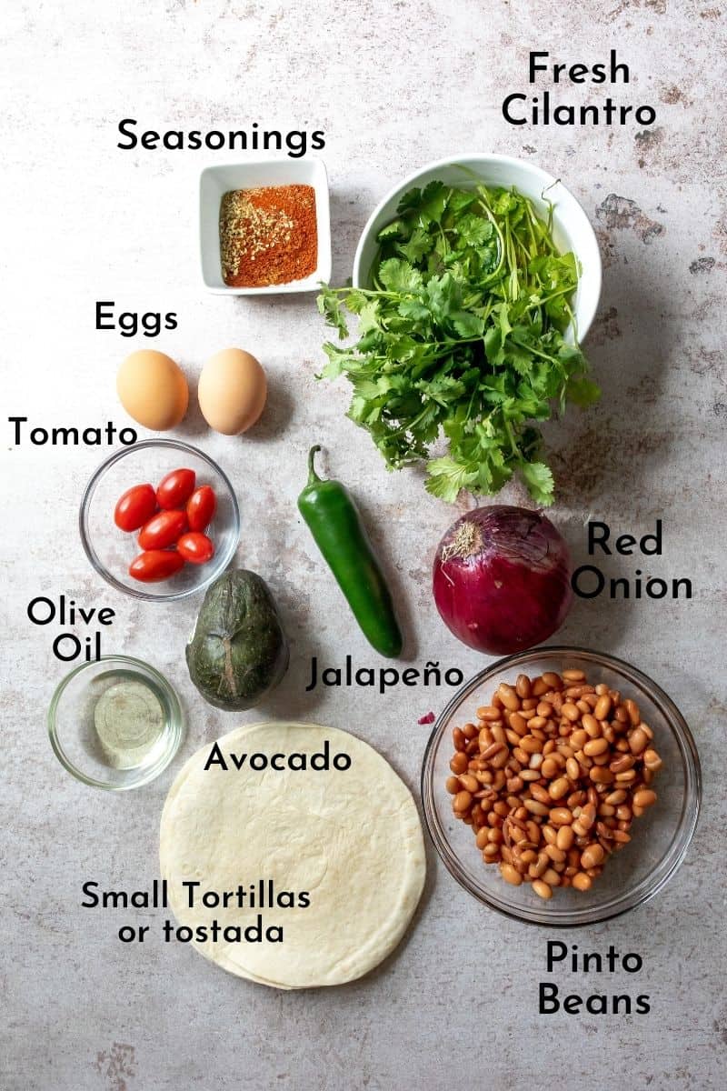 ingredients to make breakfast tostadas on a grey counter. 