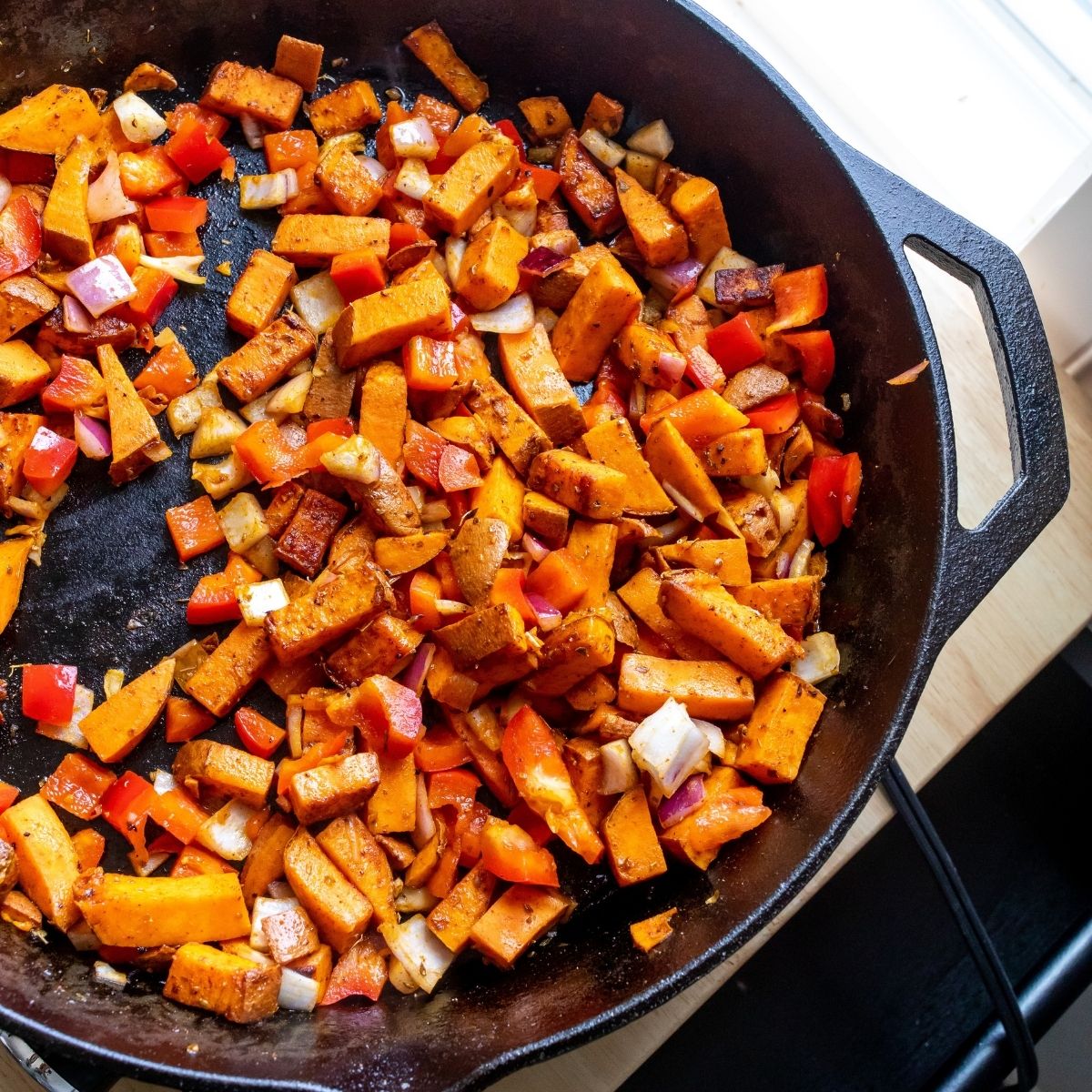 Sweet Potato Breakfast Hash With Fried Eggs in a skillet.