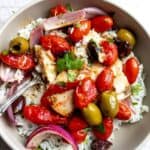 Baked Mediterranean fish in a grey bowl with olives.