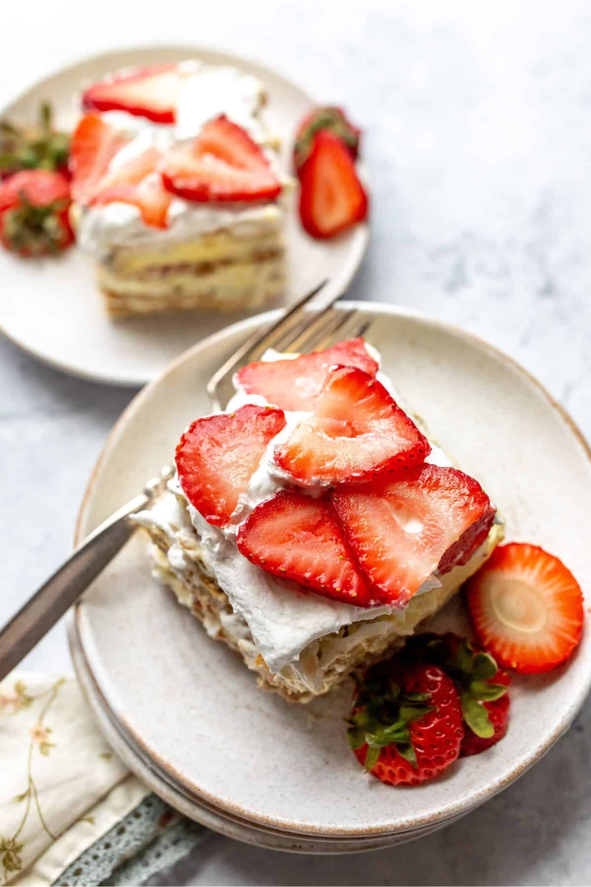 Strawberry Icebox Cake on a white plate with a silver fork.