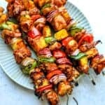Teriyaki Chicken Skewers on a plate with metal skewers.