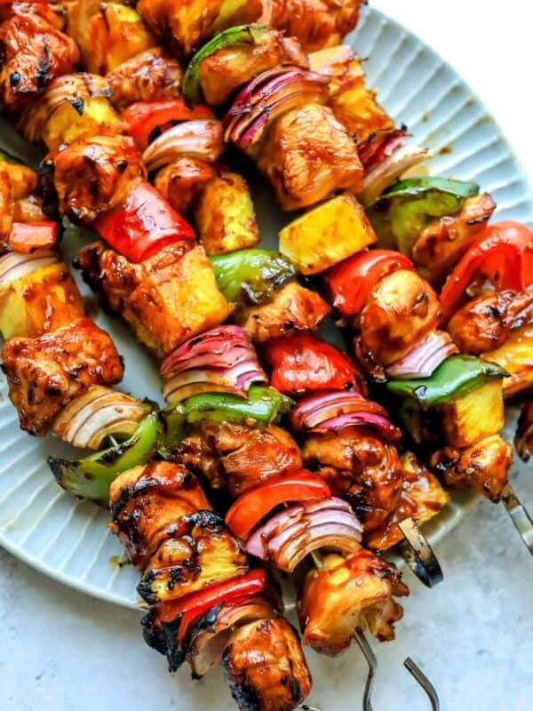 Teriyaki Chicken Skewers on a plate with metal skewers.