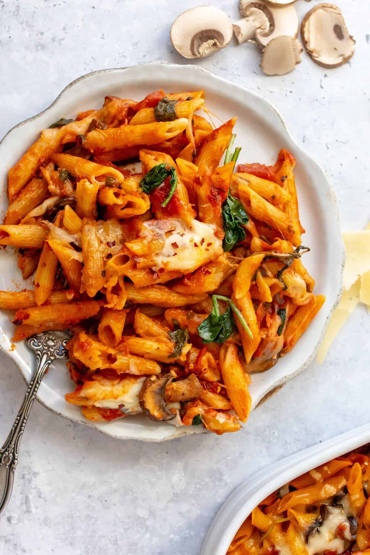 Baked Penne Pasta on white plates with a fork.