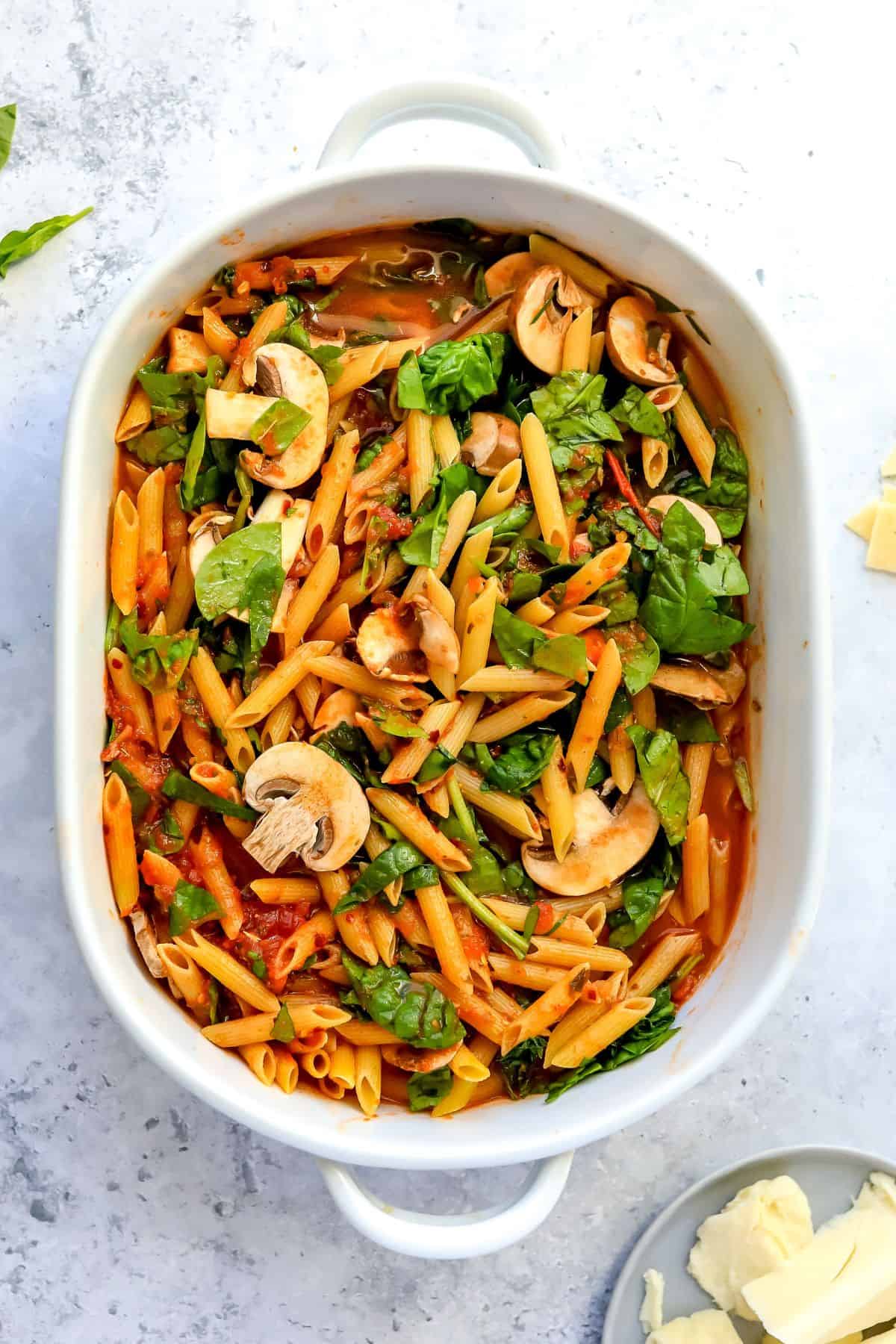 Steps to make this recipe, uncooked pasta in a white baking dish. 