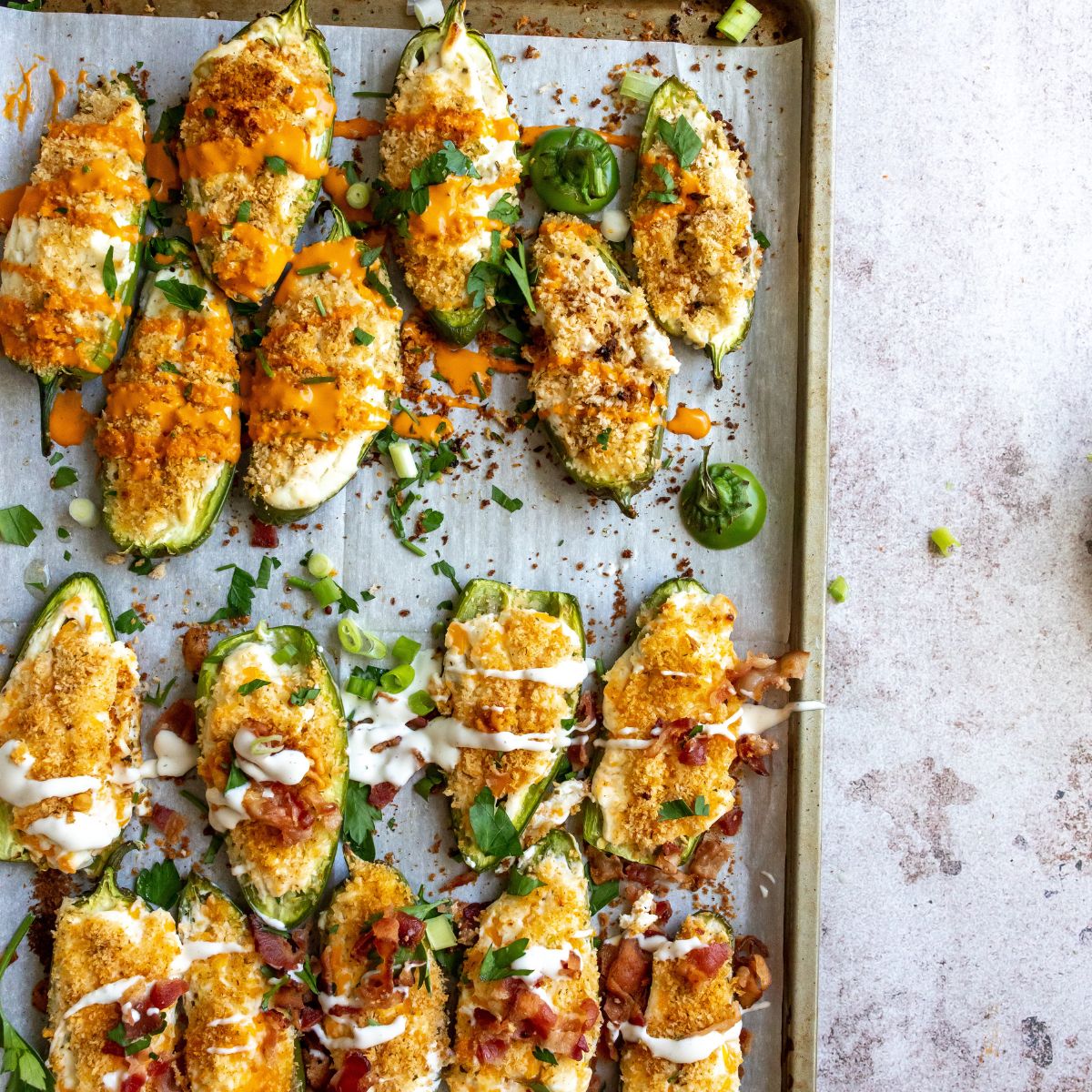Baked jalapeño poppers on a cooking sheet.