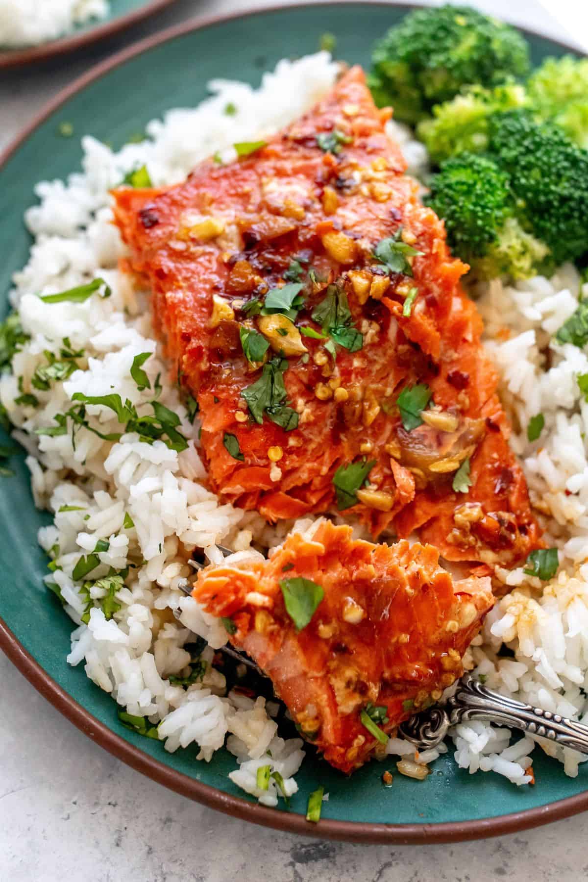 green plate with firecracker salmon on top and broccoli.