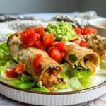 Baked Chicken Taquitos on a plate with toppings.