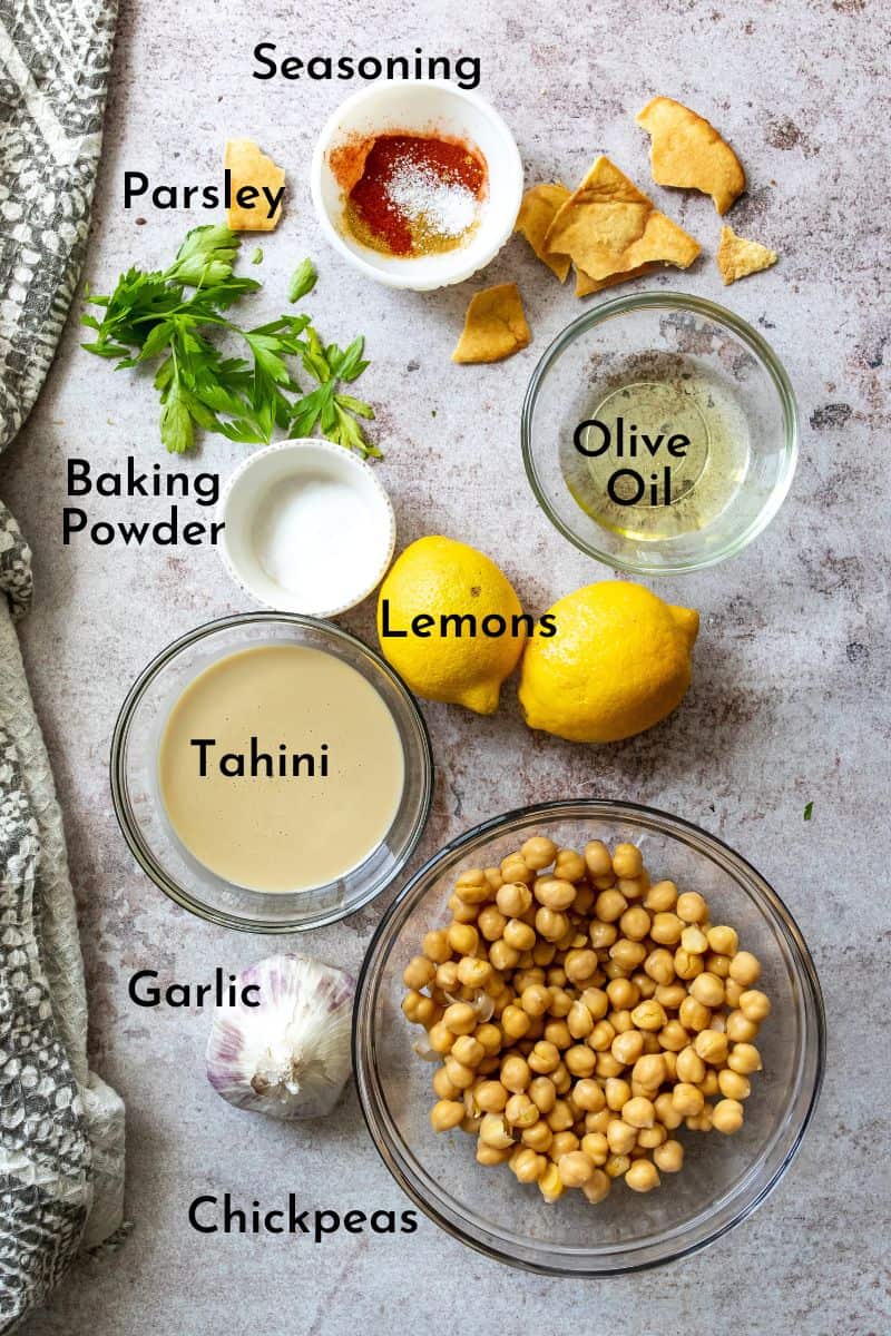 Creamy Hummus Recipe ingredients on a counter in bowls. 