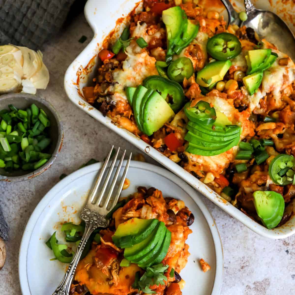 Healthier Enchilada Casserole up close with a side plate and fork. 