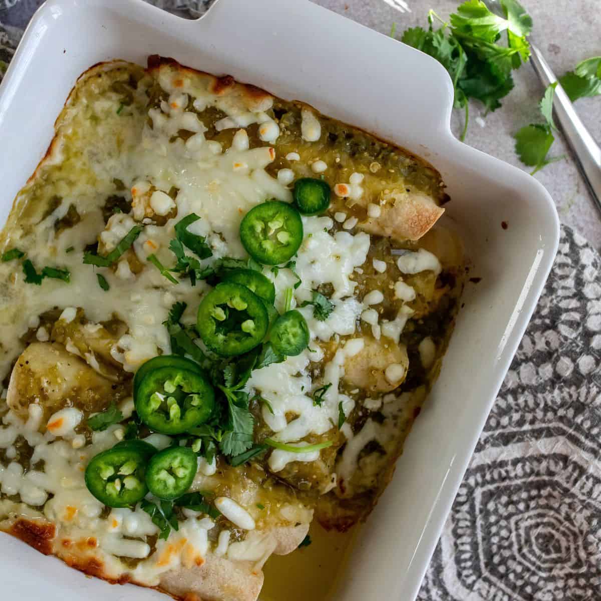 Green Chili Chicken Enchiladas made with nutritious ingredients in a baking dish.