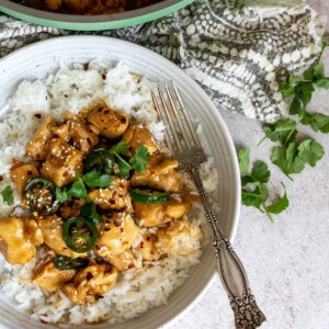 Sautéed chicken with jalapeños on a plate with a fork on the side.
