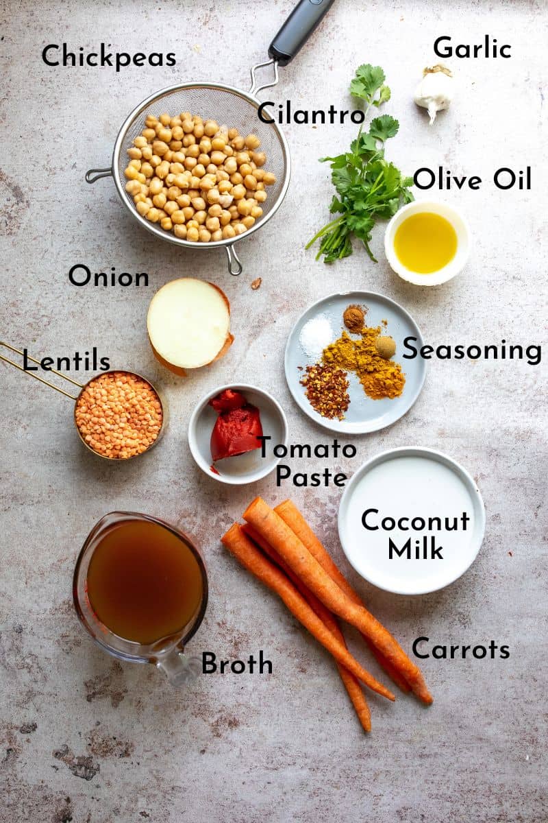 Ingredients needed to make carrot and lentil soup on a counter in small bowls. 