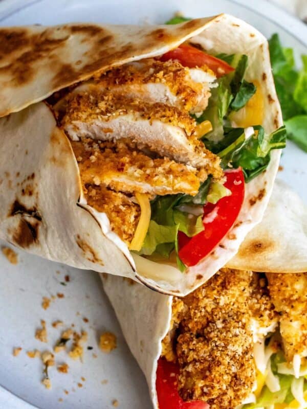 Crispy Chicken Wraps on a white plate with lettuce and tomato.