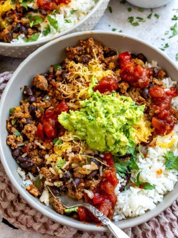 Grey bowl with taco rice in it and guac on top.