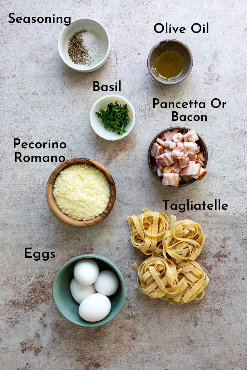 Ingredients on a counter in small bowls to make Tagliatelle Carbonars.