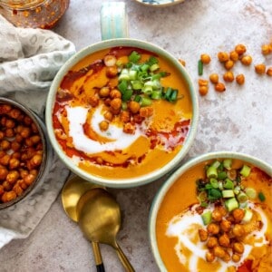 Lentil and carrot soup in a green mug with chili crunch.