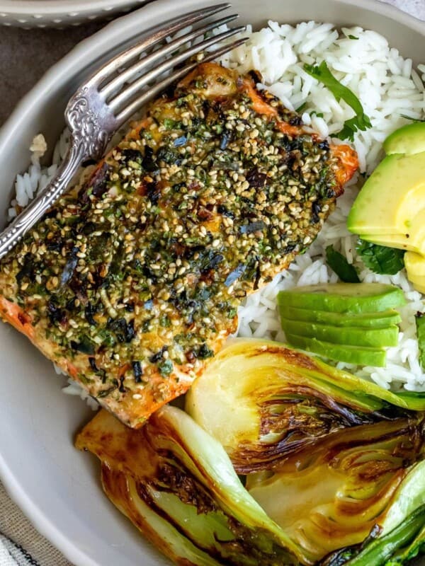 Salmon on white rice with green veggies and a fork.