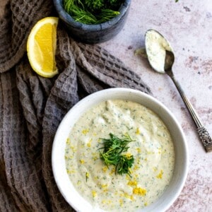 Dressing in a white bowl with a spoon.