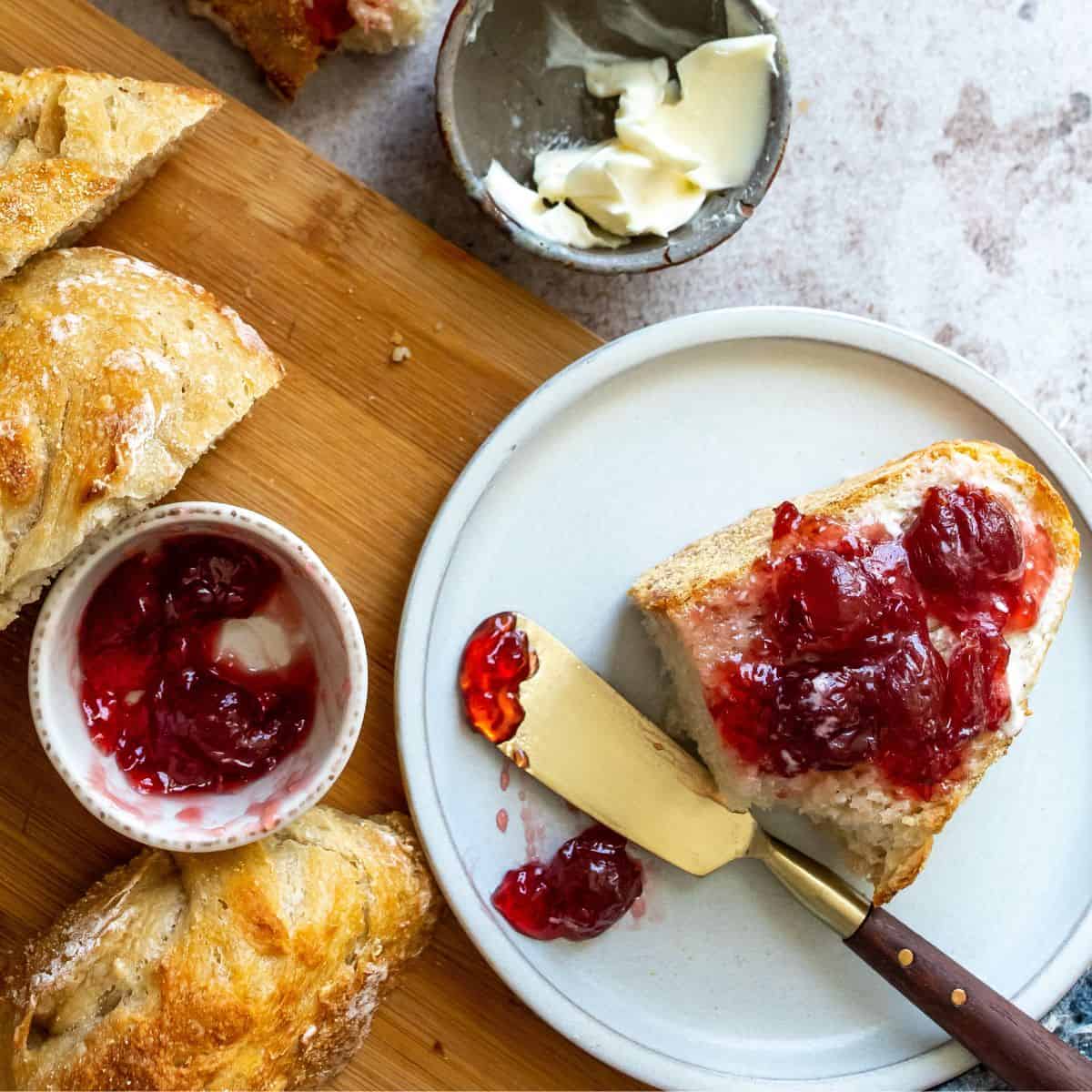 Bread on a white plate with jam on it. 