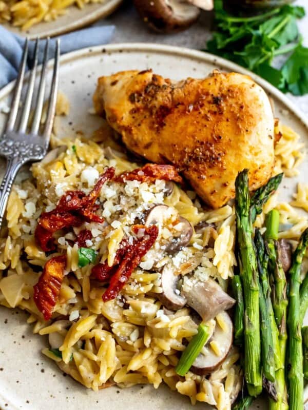 Chicken and orzo on a plate with asparagus.