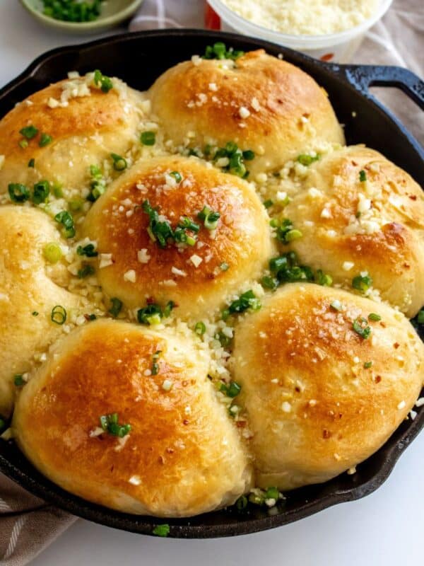 Garlic rolls in a cast iron with chives on top.