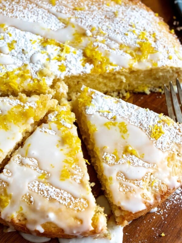 Cake with lemon zest on a cutting board.