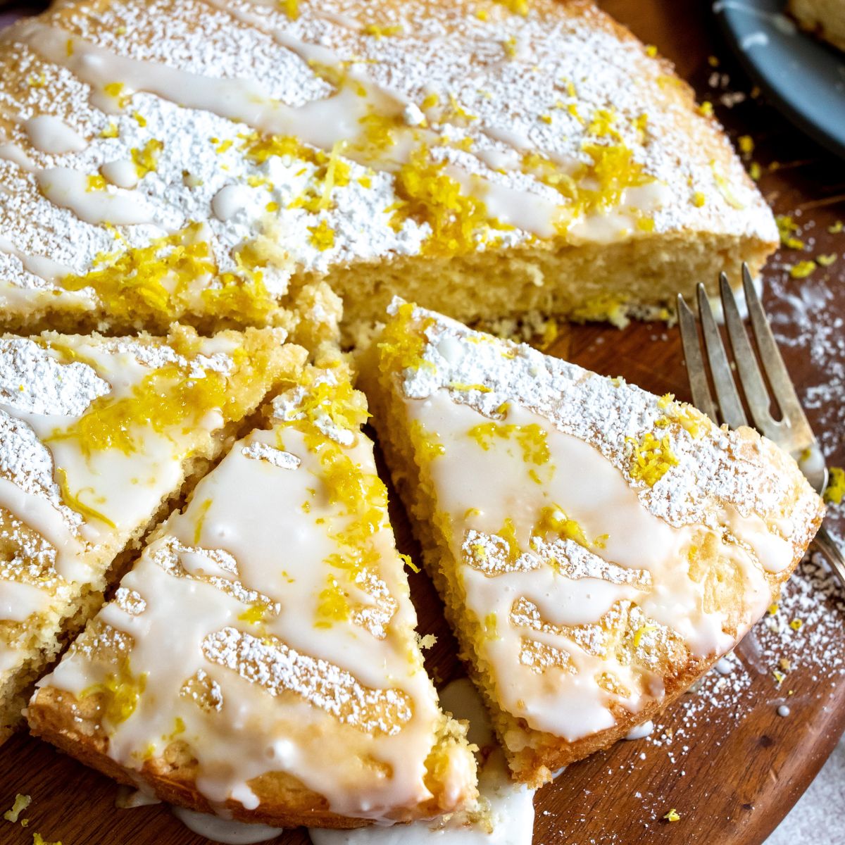 Lemon cake with powdered sugar, icing on a cutting board. 